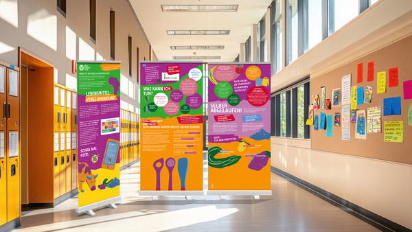 Drei farbige Roll‑up‑Banner zum Thema Lebensmittelverschwendung stehen in einem hellen Schulflur mit Spinden; sie zeigen Infografiken, Texte (z. B. „Was kann ich tun?“ und „Selber abgelaufen!“) und Illustrationen von Lebensmitteln.