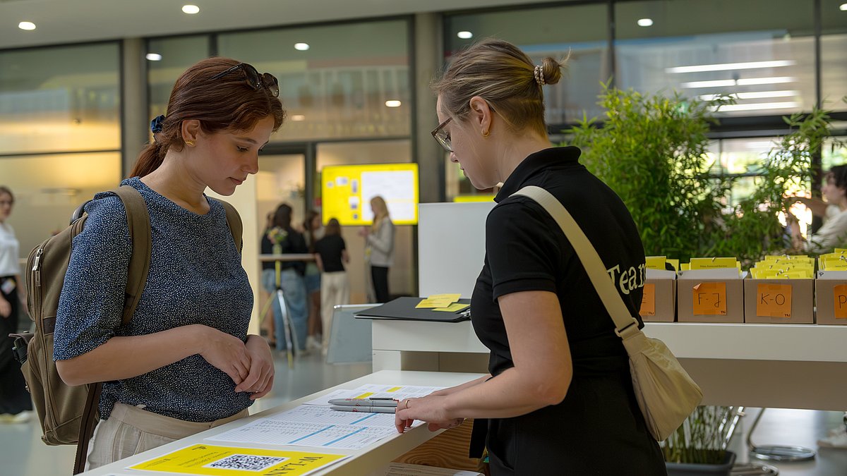 Frau informiert auf Messe Besucherin über Nachhaltige Arbeitswelt.