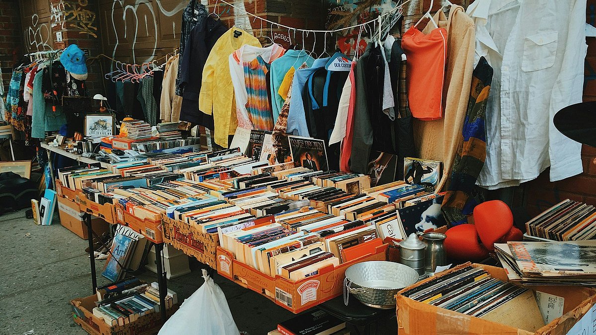 Ein Flohmarkt mit verschiedenem Krims Krams wie Kleidungsstücken und Büchern