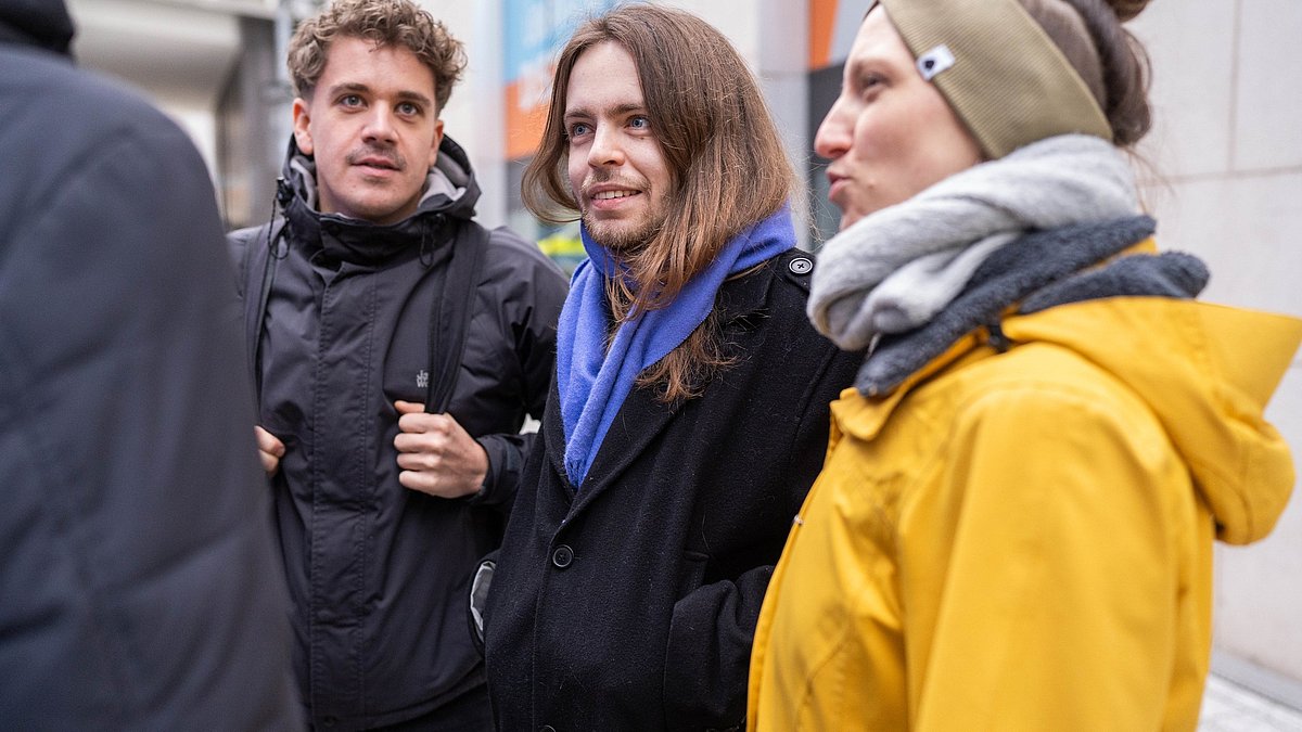 Menschen stehen draußen auf einer Stadttour zusammen