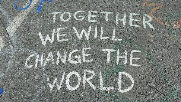 Mit Kreide auf die Straße geschriebener Spruch "Together we will change the world"