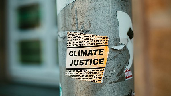 Ein Aufkleber an einer Straßenlaterne mit der Aufschrift "Climate Justice"