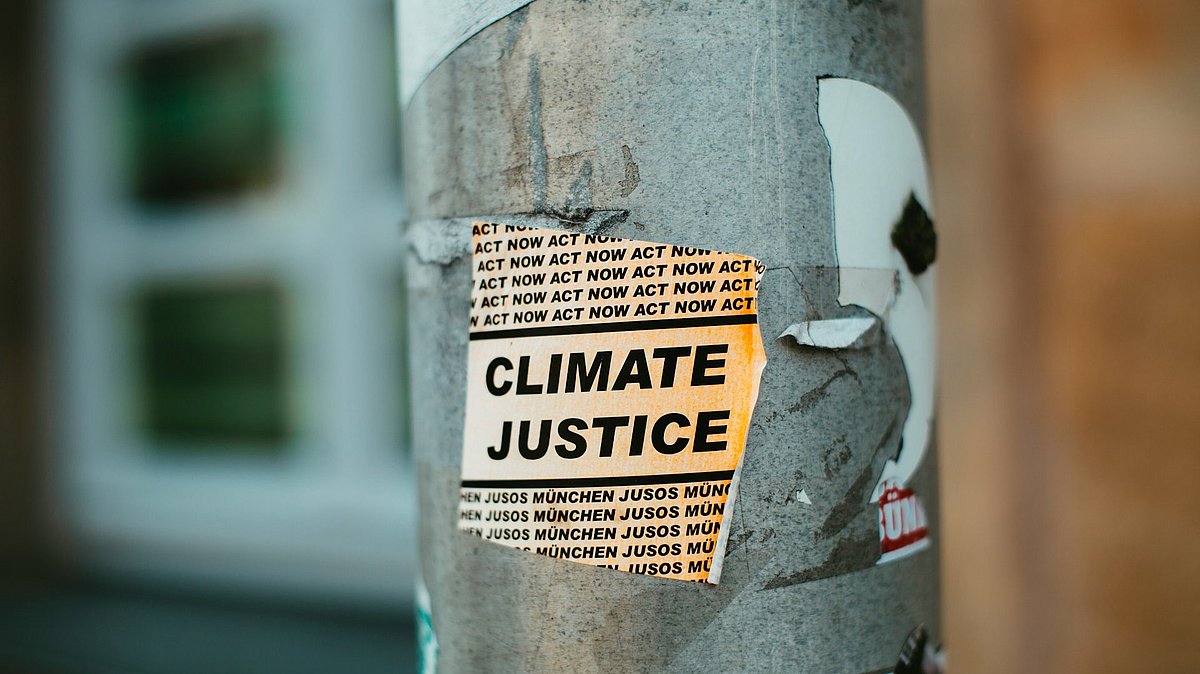 Ein Aufkleber an einer Straßenlaterne mit der Aufschrift "Climate Justice"