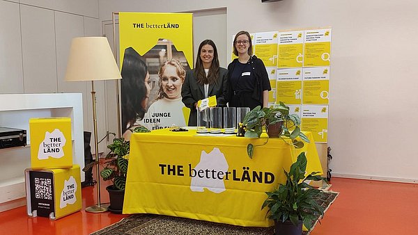 Zwei Frauen stehen vor dem Infostand von THE betterLÄND