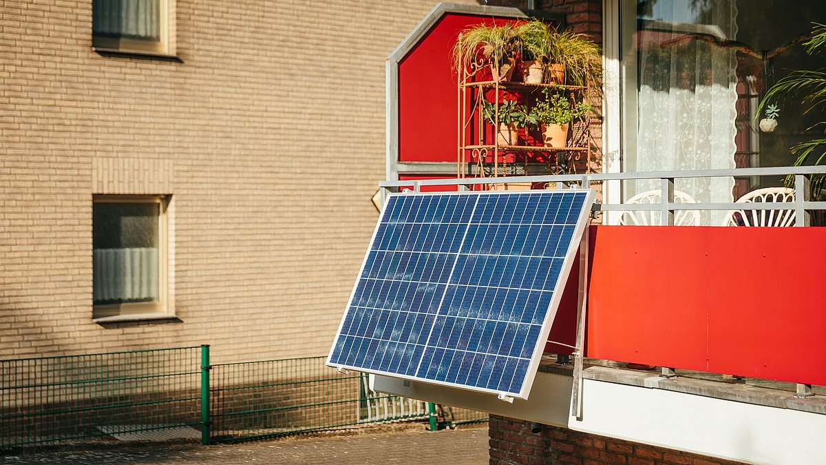 Balkon mit montierter Solarzelle, die an der Brüstung befestigt ist und zur Stromerzeugung genutzt wird.